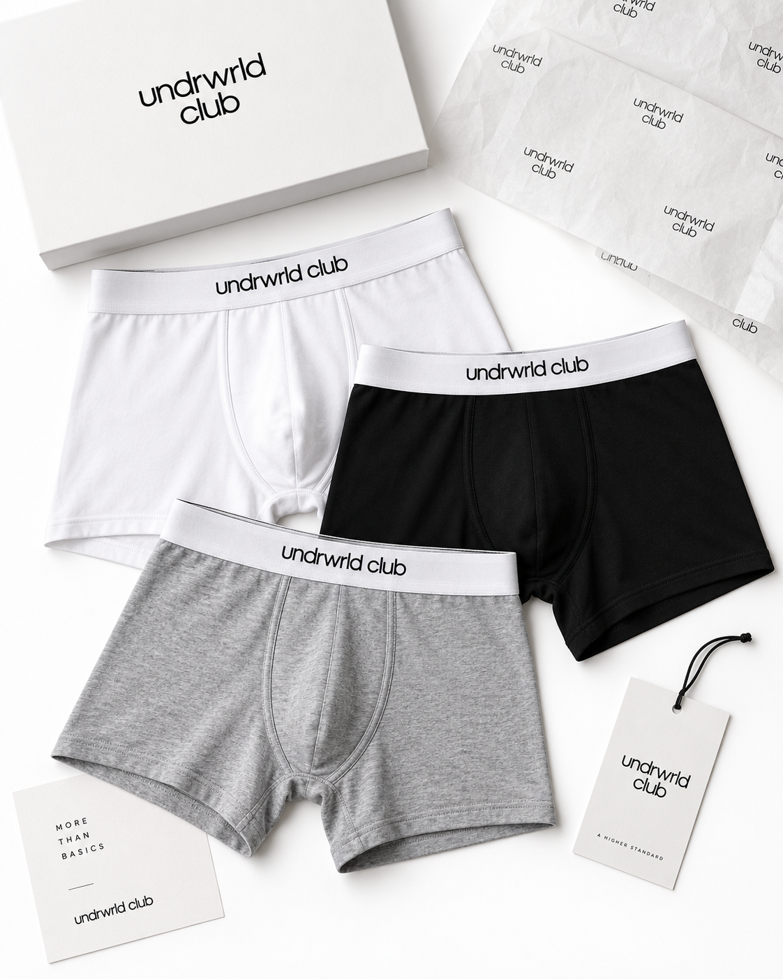 White, black, and gray undrwrld club boxer briefs arranged with branded packaging